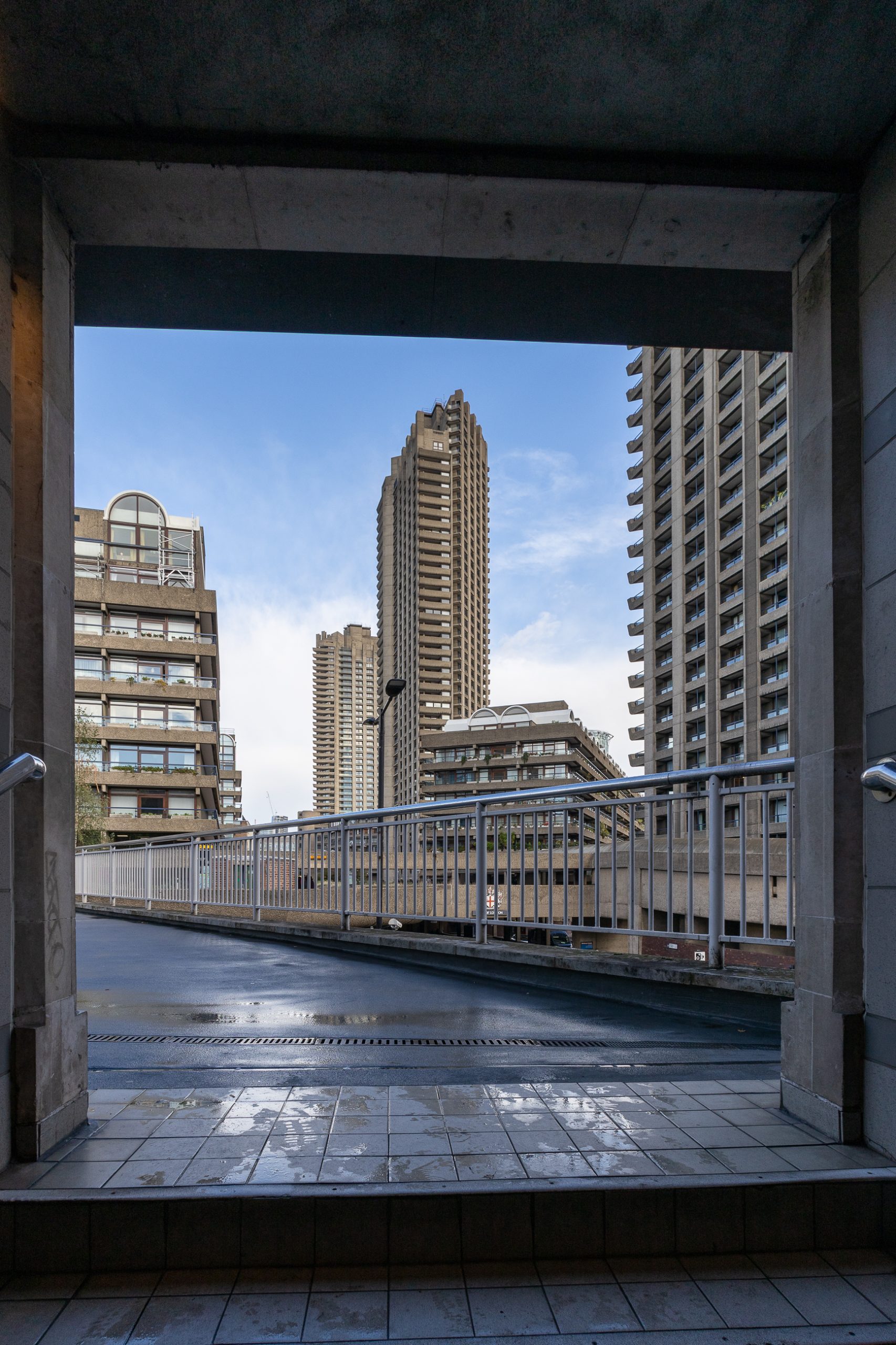 Photo showing the Barbican Estate towers framed by the exit onto a walkway