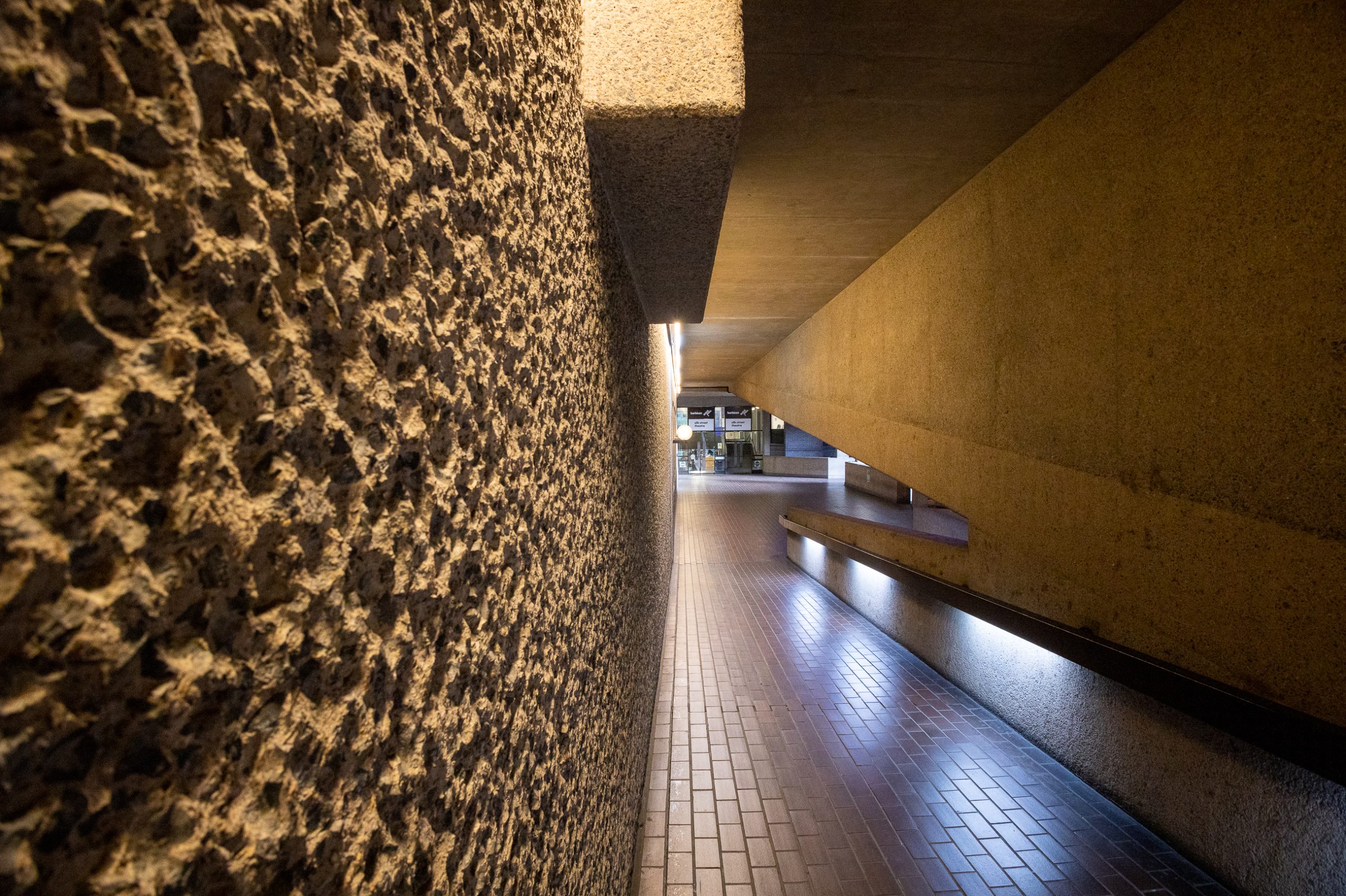 A downward-sloping interior corridor showing details of the wall texture on the left