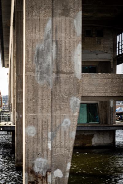 Beautifully aged concrete previously supporting a 270m long crane track formerly used by the NDSM shipbuilders. the cranes have been replaced with a striking three storey transparent office block.