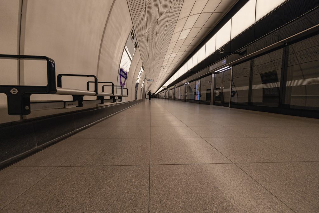 A low-level picture of the Farringdon Station, westbound platform showing the scale of the structure and highlighting the detail of the underground roundel on the seating